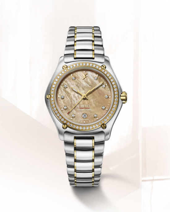 staal/gouden Ebel 1911 Lady, 30 mm kast, de band is staal/pvd en de kast is staal met 18 krt geelgoud, beige kleurig parelmoer wijzerplaat welke is verfraaid met 10 briljant geslepen diamanten en de gouden lunette is ook verfraaid met briljant geslepen di