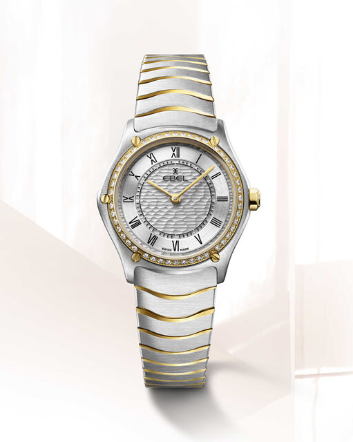 Ebel Sport Classic 29 mm , de kast is een combinatie van staal + 18 krt geelgoud en de band een combinatie van staal en geel PVD, wijzerplaat zilverkleurig en romeinse cijferweergave, de gouden lunette is bezet met 47 diamanten totaal 0.306 crt G/VS, kast