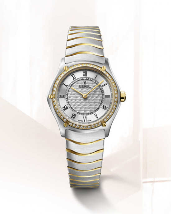 Ebel Sport Classic 29 mm , de kast is een combinatie van staal + 18 krt geelgoud en de band een combinatie van staal en geel PVD, wijzerplaat zilverkleurig en romeinse cijferweergave, de gouden lunette is bezet met 47 diamanten totaal 0.306 crt G/VS, kast